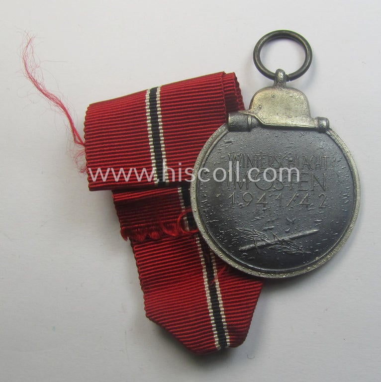 Medal-set: 'Winterschlacht im Osten 1941-42' being a non-maker-marked- (and/or 'Feinzink'-based) specimen that comes together with its (minimally confectioned) ribbon (ie. 'Bandabschnitt')
