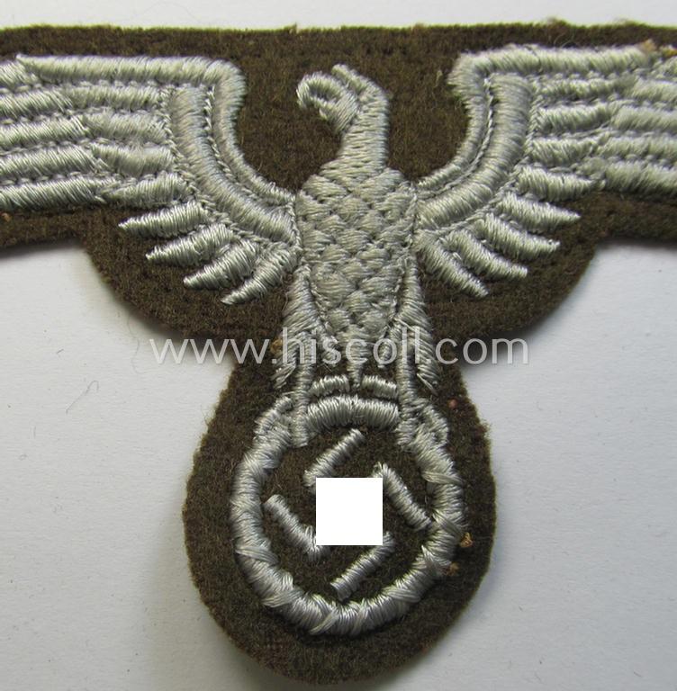 Attractive, machine-embroidered arm-eagle (ie. 'Ärmeladler') as was specifically intended for usage on the brownish-green-coloured tunics of officials of the: 'Reichsministerium für besetzte Ostgebiete' (ie. 'R.M.b.O.')