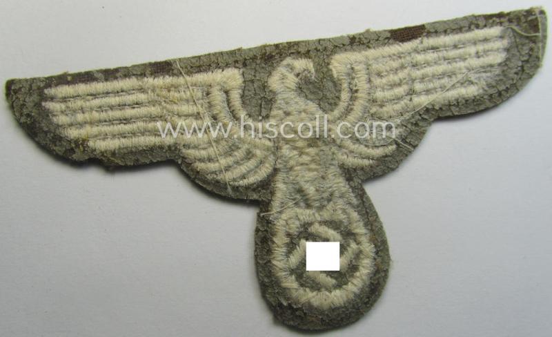 Machine-embroidered arm-eagle (ie. 'Ärmeladler') as was specifically intended for usage on the brownish-green-coloured tunics of officials of the: 'Reichsministerium für besetzte Ostgebiete' (ie. 'R.M.b.O.')