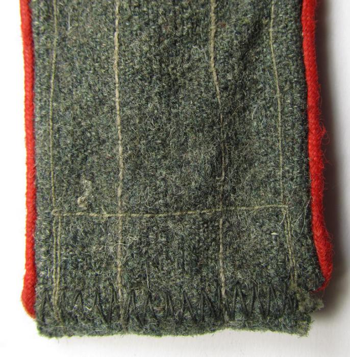 Single, later-war-period-, so-called: 'M44'-pattern, simplified WH (Heeres) enlisted-mens'-type shoulderstrap as piped in the bright-red-coloured branchcolour as was intended for usage by a: 'Soldat der (Sturm)Artillerie-Truppen'