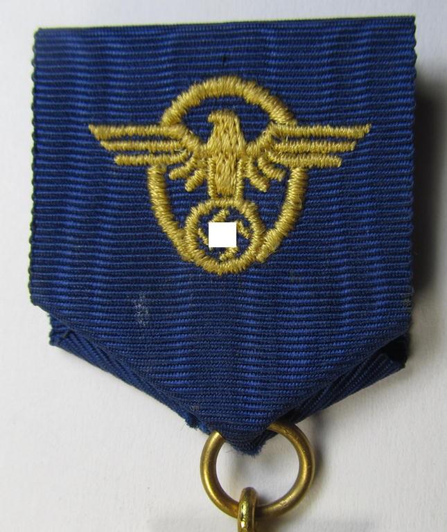 Attractive, golden-class 'Polizei-Dienstauszeichnung 1. Stufe' (or: police loyal-service medal first-class) being a non-maker-marked example that comes mounted onto its accompanying (long-sized!) ribbon (ie. 'Bandabschnitt')