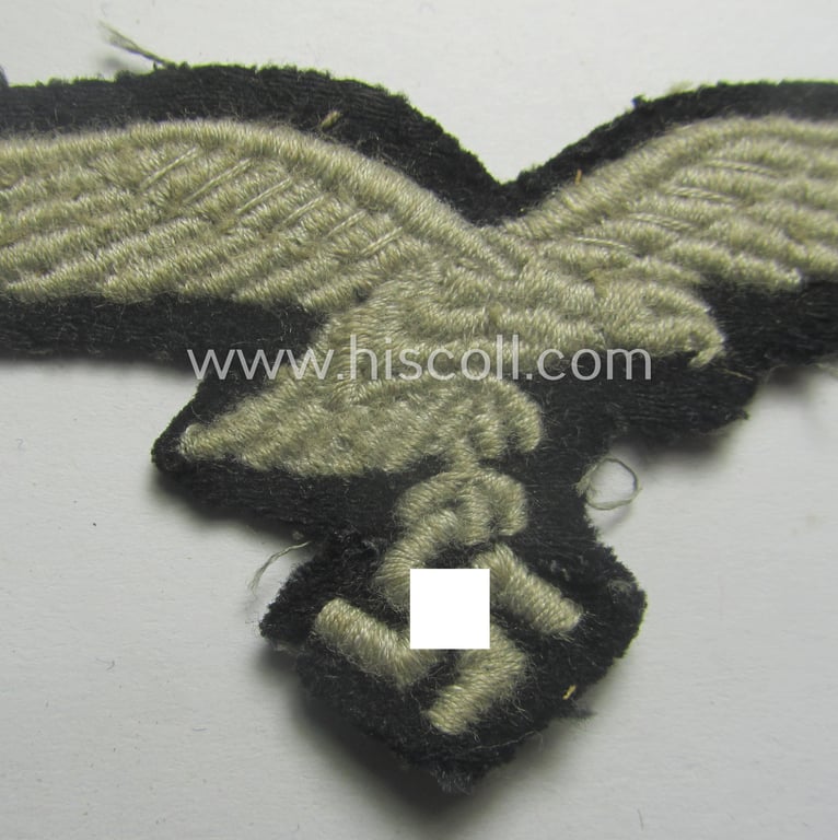 Minimally used, WH (Luftwaffe) cap-eagle (being a 'standard-issue'-pattern example that is executed onto a black-coloured background and that was as such intended for usage on the black-coloured work- ie. 'HG'-related side-caps ie. 'Schiffchen')