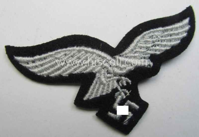 WH (Luftwaffe) cap-eagle (being a 'standard-issue'-pattern example that is executed onto a black-coloured background and that was as such intended for usage on the black-coloured work- ie. 'HG'-related side-caps ie. 'Schiffchen')