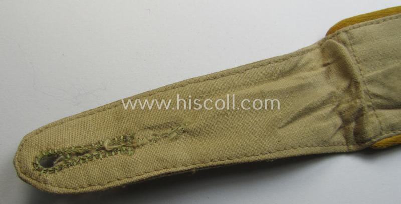 Single, WH (Luftwaffe) tropical-issued, EM-type-shoulderstrap as executed in beige-coloured linnen (as was specifically intended for usage on the tropical-shirts ie. tunics) as was intended for a: 'Soldat der Flieger- o. Fallschirmjäger-Truppen'