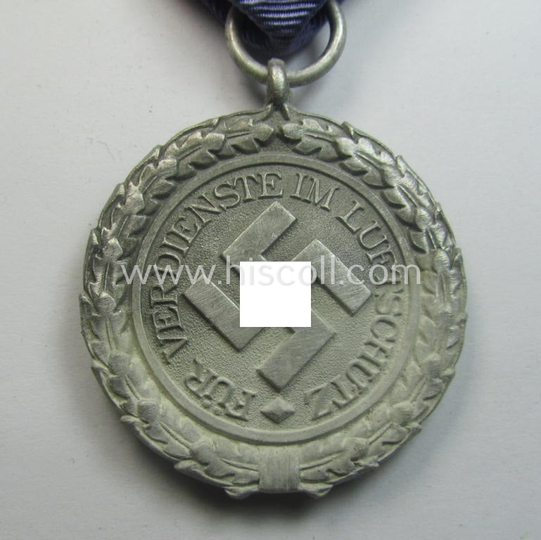 Light-weight (ie. typical aluminium-based) medal as was intended for air-raid wardens 2nd. class (or: 'Luftschutz-Ehrenzeichen 2. Stufe') that comes stored in its period, dove-grey-coloured etui