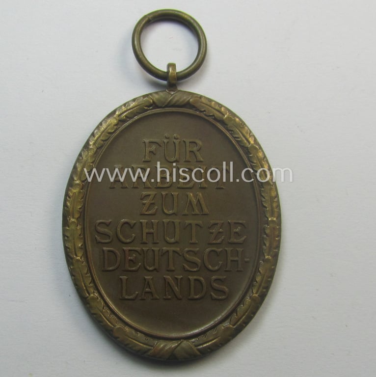Medal-set: 'Deutsches Schutzwall Ehrenzeichen' (aka: 'Westwall'-medal) being a (typical) non-maker-marked- and/or: typical 'Buntmetall'-based specimen that comes packed in its original pouch of issue by the: 'Ferd. Hoffstätter'-company