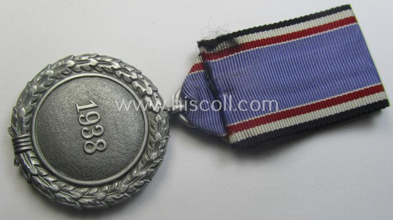 'Luftschutz-Ehrenzeichen 2. Stufe' being a maker- (ie. '10'-) marked example, as executed in (heavy) zinc-based metal (ie. 'Feinzink') and that came together with its period ribbon (ie. 'Bandabschnitt')