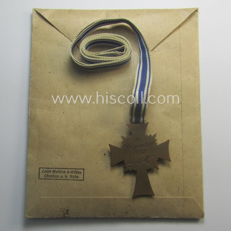 'Ehrenkreuz der deutschen Mutter - dritte Stufe' (or: bronze-class mothers'-cross) that came mounted onto its long-sized ribbon and that came stored in its period pouch by the maker: 'Louis Gottlieb - Oberstein a.d. Nahe'