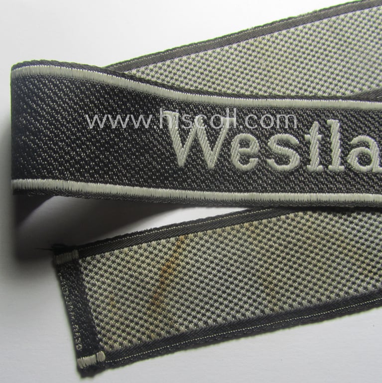 Waffen-SS, 1943/44 pattern cuff-title (ie. 'Ärmelstreifen') depicting the machine-woven Latin script text in silver-grey linnen as was intended for a member of the: 'SS-Regiment': "Westland" (ie. part of the: '5. SS-Pz-Gren.-Div. "Wiking")
