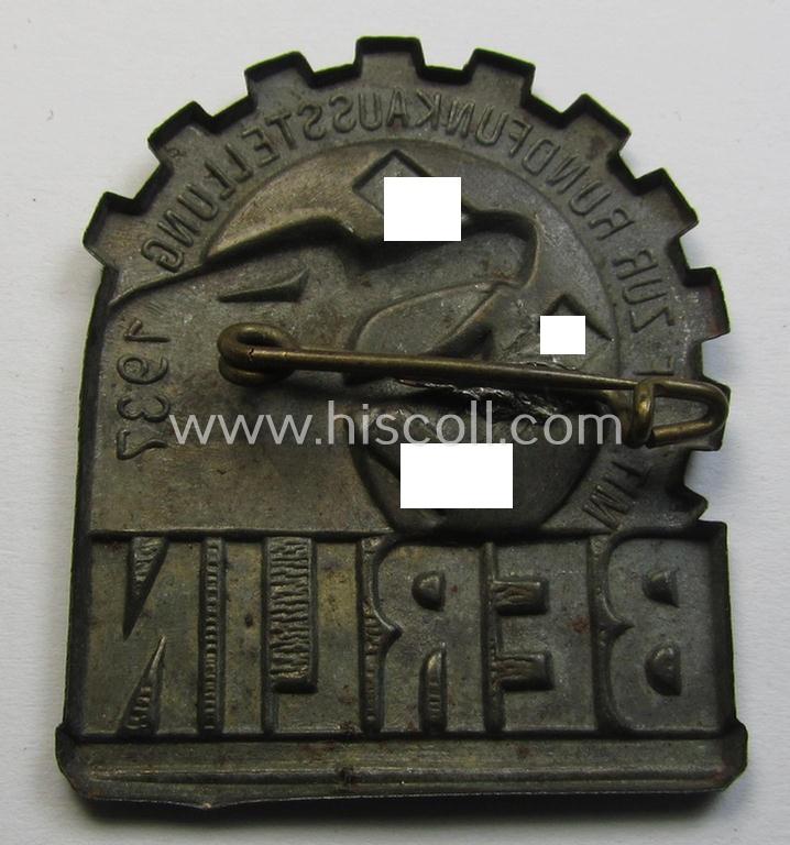Attractive, so-called: 'KdF'- ('DAF- o. Kraft durch Freude'-) related day-badge (ie. 'tinnie') depicting a eagles'-head, 'DAF-Zahnrad' and text that reads: 'Mit KDF zur Rundfunkaustellung - Berlin - 1937'