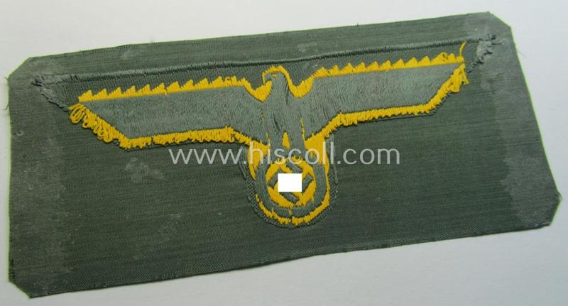 WH (Kriegsmarine) ie. 'Küst.-Art.'-related breast-eagle (ie. 'Brustadler für Mannschaften u. Uffz. der Küsten-Artillerie-Truppen') being a 'standard-issue'-pattern-example as executed in the 'BeVo'-weave-pattern on a field-grey-coloured backg...