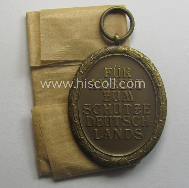 Stunning, 'Deutsches Schutzwall Ehrenzeichen' (aka: 'Westwall'-medal) being a (typical) non-maker-marked- and/or: 'Buntmetall'-based specimen that comes packed in its original pouch of issue by the: 'Friedrich Orth'-company