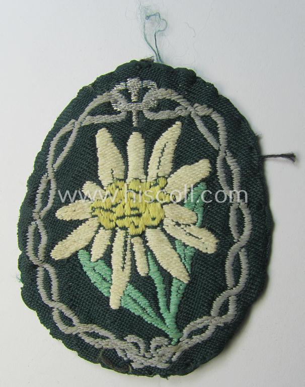 Truly used and/or tunic-removed, WH (Heeres) EM- (ie. NCO-) type, so-called: 'Edelweiss'-armpatch being a 'BeVo'-woven example as was executed on darker-green linnen as was specifically intended for usage by the: 'Gebirgsjäger-Truppen'