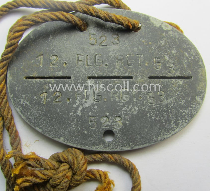 Zinc-based, WH (LW) ie. 'Flieger'-related ID-disc bearing the clearly stamped unit-designation that simply reads: '12. Flg.Rgt. 53' (and as such belonging to a staff-member serving within the: 'Luftgau-Feld-Regiment Belgien-Nordfrankreich')