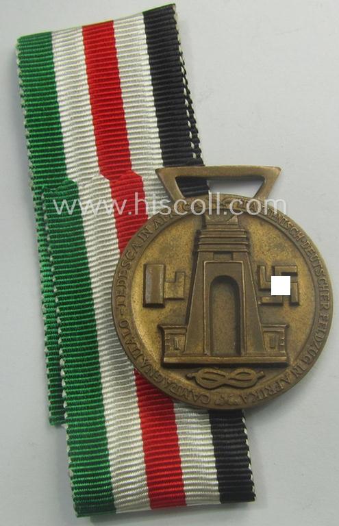 Golden-bronze-coloured (and 'Buntmetall'-based!) example of a: 'Deutsch-Italienische Feldzugsmedaille' (or: German-Italian campaign-medal) that came together with its (full length- and virtually mint- ie. unissued) piece of original ribbon