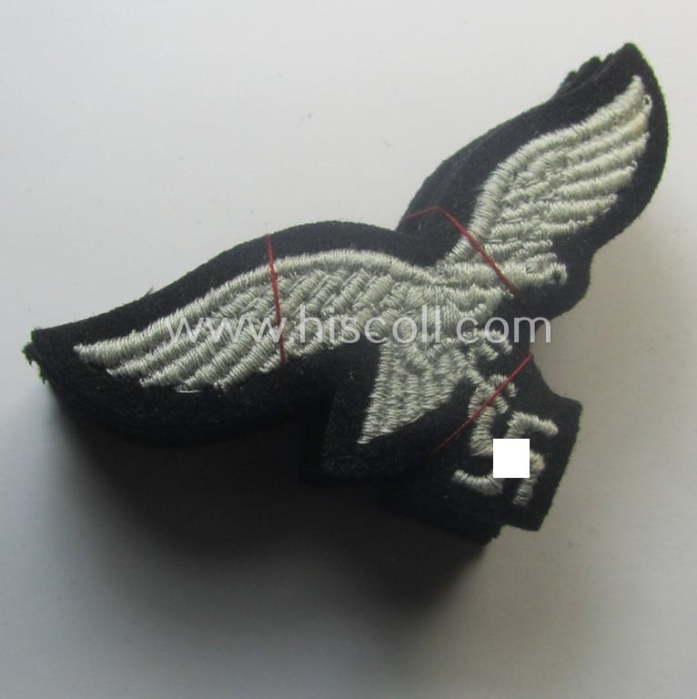 WH (Luftwaffe) cap-eagle (being a 'standard-issue'-pattern example that is executed onto a black-coloured background and that was as such intended for usage on the black-coloured work- ie. 'HG'-related side-caps ie. 'Schiffchen')