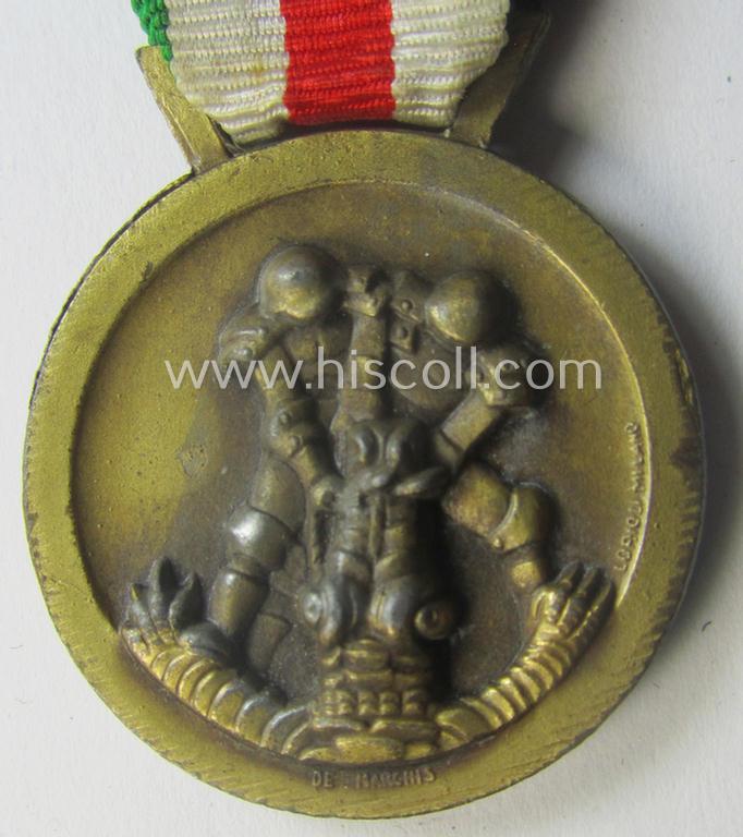 Golden-bronze-coloured (and zinc-based!) example of a: 'Deutsch-Italienische Feldzugsmedaille' (or: German-Italian campaign-medal) that comes mounted onto its (regular-sized) piece of original (and minimally faded- ie. stained!) ribbon