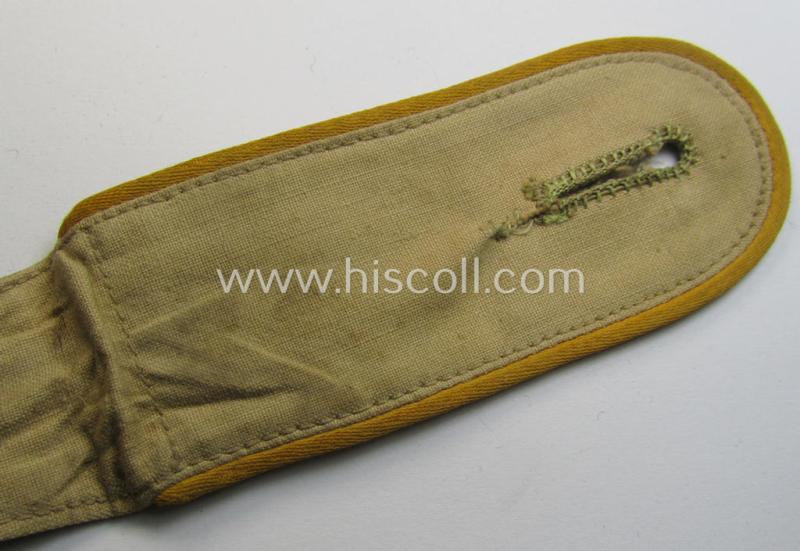 Single, WH (Luftwaffe) tropical-issued, EM-type-shoulderstrap as executed in beige-coloured linnen (as was specifically intended for usage on the tropical-shirts ie. tunics) as was intended for a: 'Soldat der Flieger- o. Fallschirmjäger-Truppen'