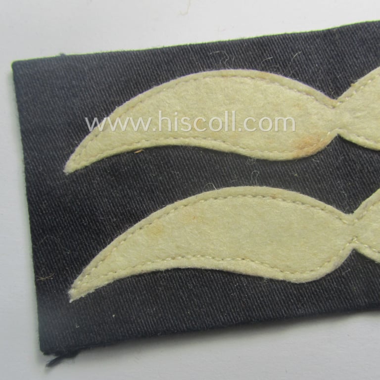 Single, WH (Luftwaffe) darker-blue-coloured- (and/or unusually linnen-based!) NCO-type rank-patch (aka 'rank-moustache') as was intended for usage by a non-commissioned officer holding the rank of an: 'Unterfeldwebel o. Unterwachtmeister'