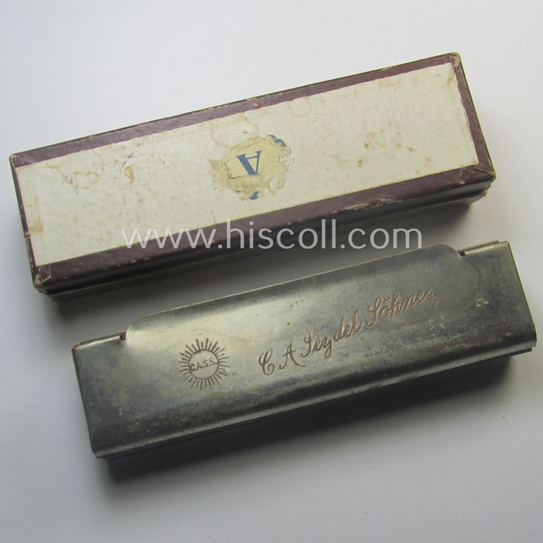Neat, typical TR-era- (ie. 'Deutsche Wehrmacht'-) related harmonica entitled: 'Unsere Feldgrauen' that came stored in its original and/or carton-based box ie. etui