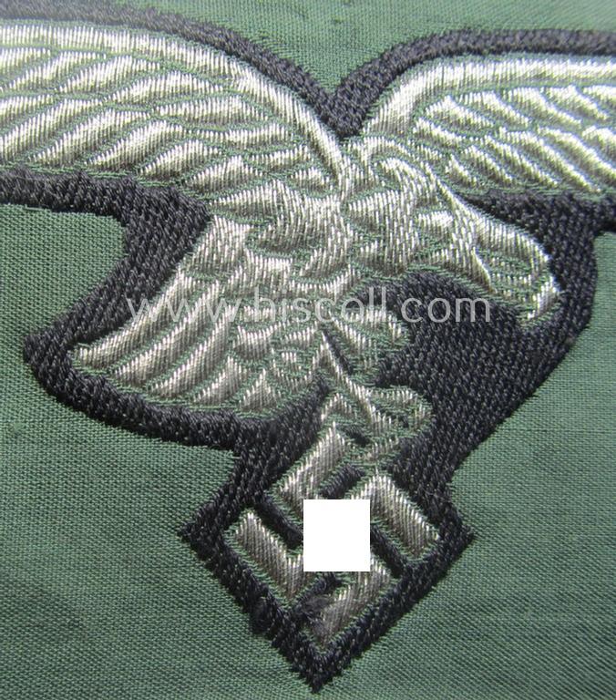 WH (Luftwaffe) officers'- (ie. evt. NCO-) type breasteagle (ie. 'Brustadler') as was executed in neatly machine-woven silver-coloured thread (ie. 'flatwire-style') onto a darker-blue- (ie. field-grey-) coloured- and/or linnen-based background