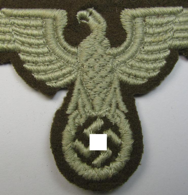 Attractive, machine-embroidered arm-eagle (ie. 'Ärmeladler') as was specifically intended for usage on the brownish-green-coloured tunics of officials of the: 'Reichsministerium für besetzte Ostgebiete' (ie. 'R.M.b.O.')