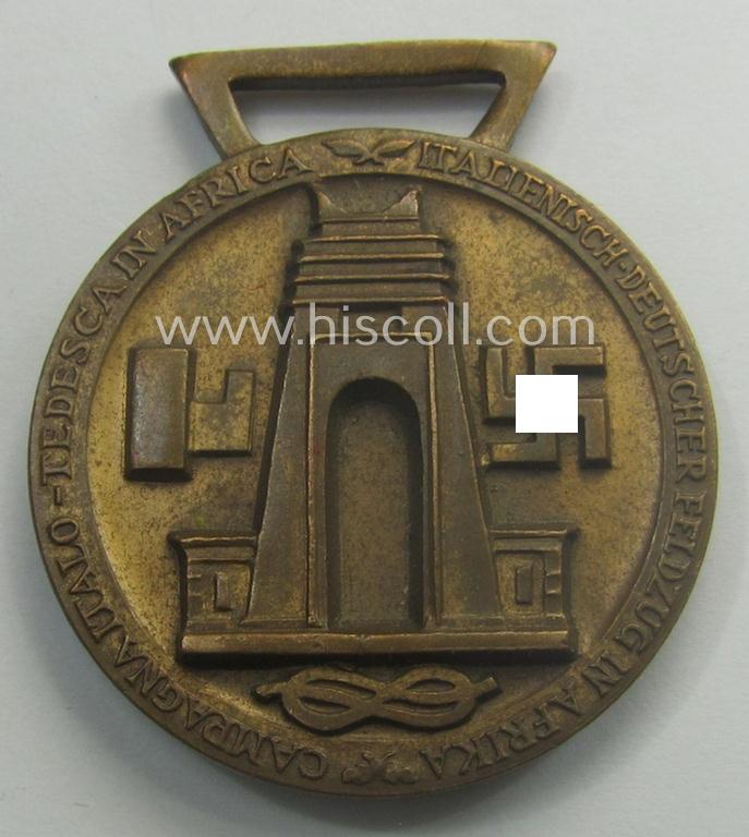 Golden-bronze-coloured (and 'Buntmetall'-based!) example of a: 'Deutsch-Italienische Feldzugsmedaille' (or: German-Italian campaign-medal) that came together with its (full length- and virtually mint- ie. unissued) piece of original ribbon