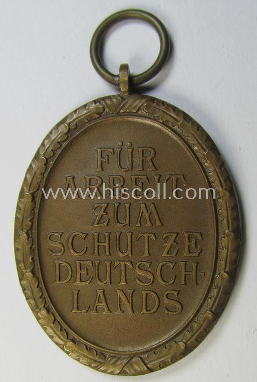 Medal-set: 'Deutsches Schutzwall Ehrenzeichen' (aka: 'Westwall'-medal) being a non-maker-marked- and/or: 'Buntmetall'-based specimen that comes together with its period- (and neatly folded ie. pre-confectioned) ribbon (ie. 'Bandabschnitt')