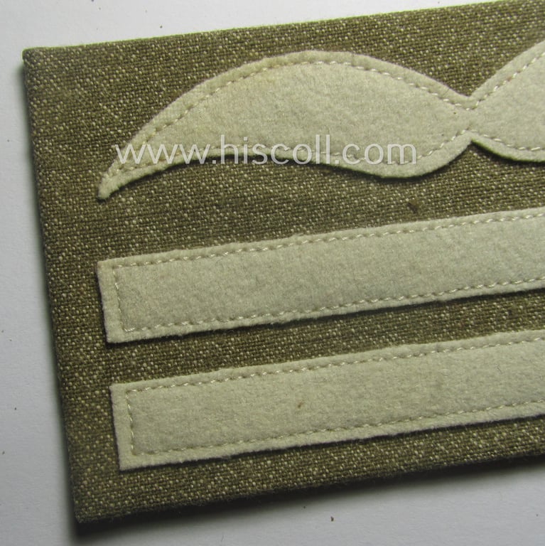 Single, WH (Luftwaffe) brownish-tan-coloured, officers'-type rank-patch (aka 'moustache'), as was intended for usage by a commissioned officer with the rank of: 'Oberleutnant' (ie. lieutnant first-class)