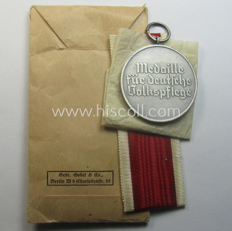 Complete medal-set: 'Medaille für Deutsche Volkspflege' being a non-maker-maker-marked specimen that comes still packed in its original pouch of issue by the 'Gebr. Godet'-company as issued and/or recently found