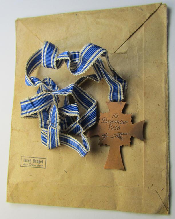 Attractive, 'Ehrenkreuz der deutschen Mutter - dritte Stufe' (or: bronze-class mothers'-cross) that came mounted onto its long-sized ribbon and that came stored in its period pouch (by the maker: 'Jakob Bengel - Idar-Oberstein')