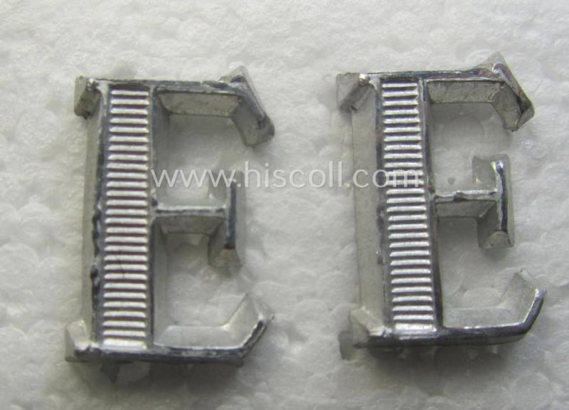 Pair of NCO-type- (thus silver-coloured), Waffen-SS- (ie. SS-VT-) related shoulderstrap-cyphers (ie. 'Schulterstückauflagen o. Ziffern') depicting a capital 'E'-character for usage by an NCO serving within the: 'Ergänzungsstellen der Waffen-SS'