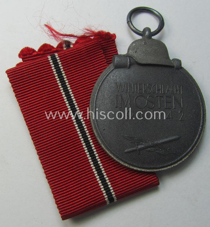 Attractive medal-set: 'Winterschlacht im Osten 1941-42' being a maker- (ie. '13'-) marked- (and/or 'Feinzink'-based) specimen by the maker: 'Gustav Brehmer' and that comes together with its (non-confectioned) ribbon (ie. 'Bandabschnitt')