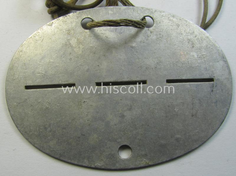 Attractive, aluminium-based WH (Heeres) (ie. 'Grenadiere'-related) ID-disc bearing the clearly stamped unit-designation that reads: 'Stammkp. G.E.B.111' and that comes still mounted onto its (period-attached) cord as issued- and/or worn
