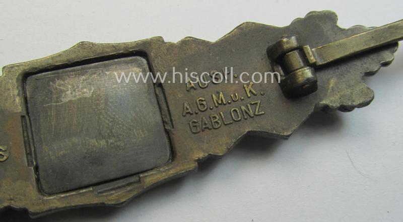 'Nahkampfspange in Bronze' (or: bronze-class close-combat clasp ie. CCC) being a maker- (ie. 'A.G.M.u.K.'-) marked- and/or minimal converse-shaped specimen having its period-attached (black-toned and steel-based) 'back-plate' in place