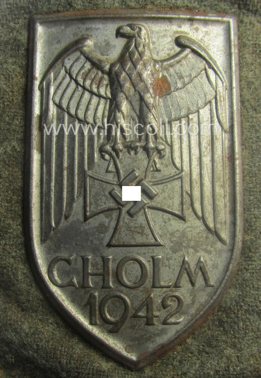 Stunning - and truly rarely encountered! - WH (Heeres ie. Waffen-SS) so-called: 'Cholm'-campaign-shield as executed in magnetic, so-called: 'Eisenblech' being a 'Long M-variant-pattern' shield that comes in a moderately used- ie. worn-, condition