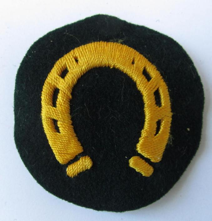 Attractive, WH (Heeres) so-called: trade- and/or special career arm-insignia, as was intended for a: 'Hufbeschlagmeister', being a neatly hand-embroidered variant on darker-green-coloured wool