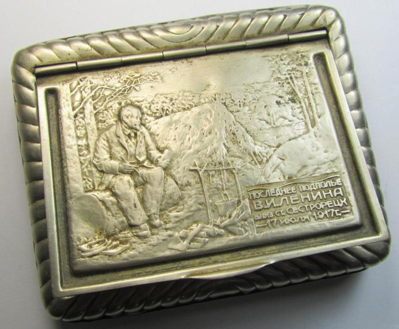 Unusal item that originated from a German soldier: a Russian, WWII-period, silver-toned tobacco-box showing a representation of Lenin coupled with some Cyrillic text (and that comes in a clearly used  condition)