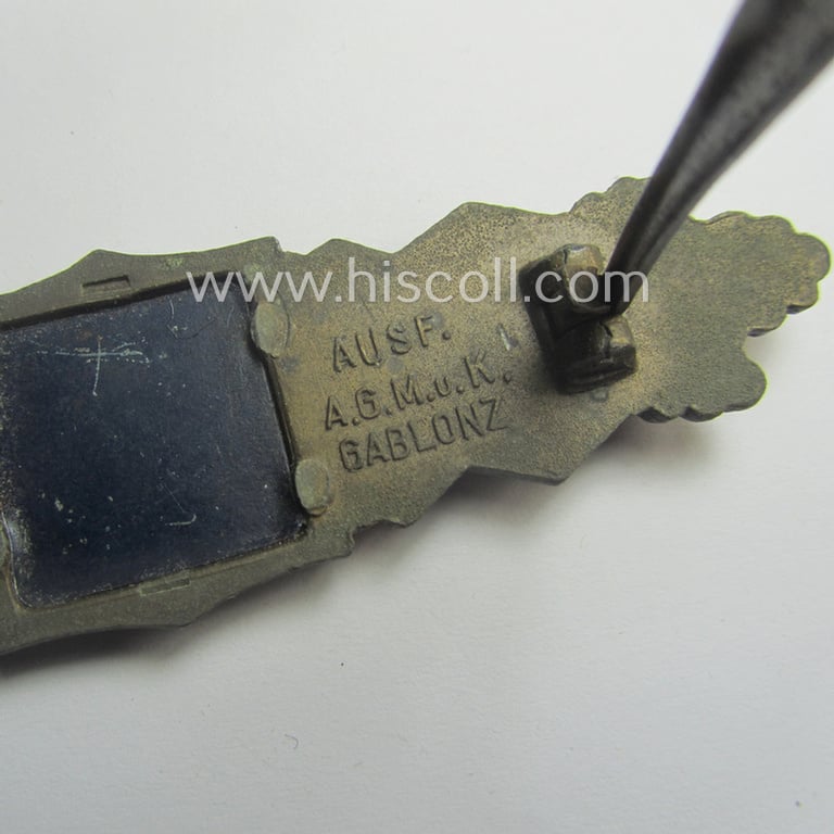 Superb, 'Nahkampfspange in Bronze' (or: bronze-class close-combat clasp ie. CCC) being a maker- (ie. 'A.G.M.u.K.'-) marked- and/or minimal converse-shaped specimen having its period-attached (black-toned and steel-based) 'back-plate' in place