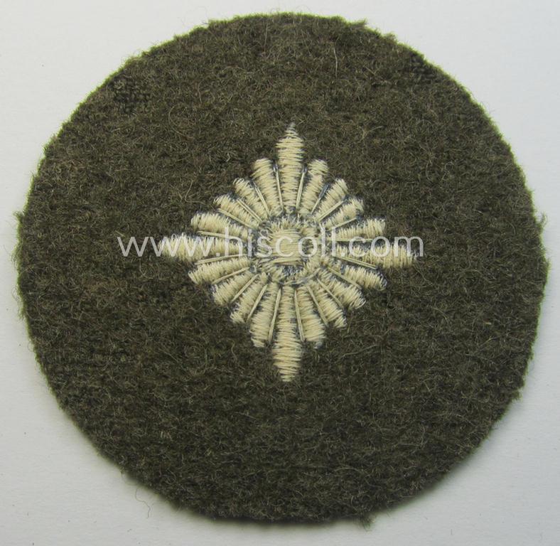 WH (Heeres) 'standard-type'- and early-pattern, tropical-style rank-insignia (ie. roundel), as executed in bluish-grey coloured linnen on a brownish-green background: 'Oberschütze'
