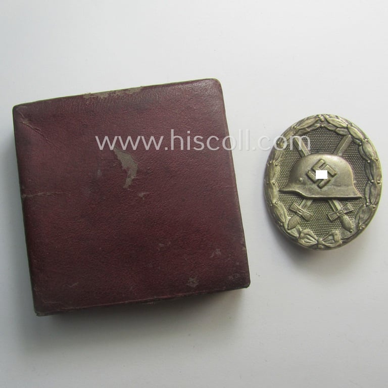 Silver-class wound-badge- (or: 'Verwundeten-Abzeichen in Silber'-) set comprising of a non-maker-marked example as produced by an unidentified 'Hersteller' and that comes stored in its typical 'LDO'-styled etui