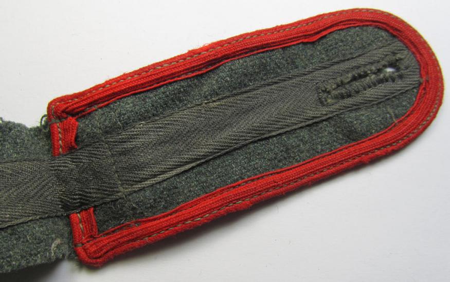 Single, later-war-period-, so-called: 'M44'-pattern, simplified WH (Heeres) enlisted-mens'-type shoulderstrap as piped in the bright-red-coloured branchcolour as was intended for usage by a: 'Soldat der (Sturm)Artillerie-Truppen'