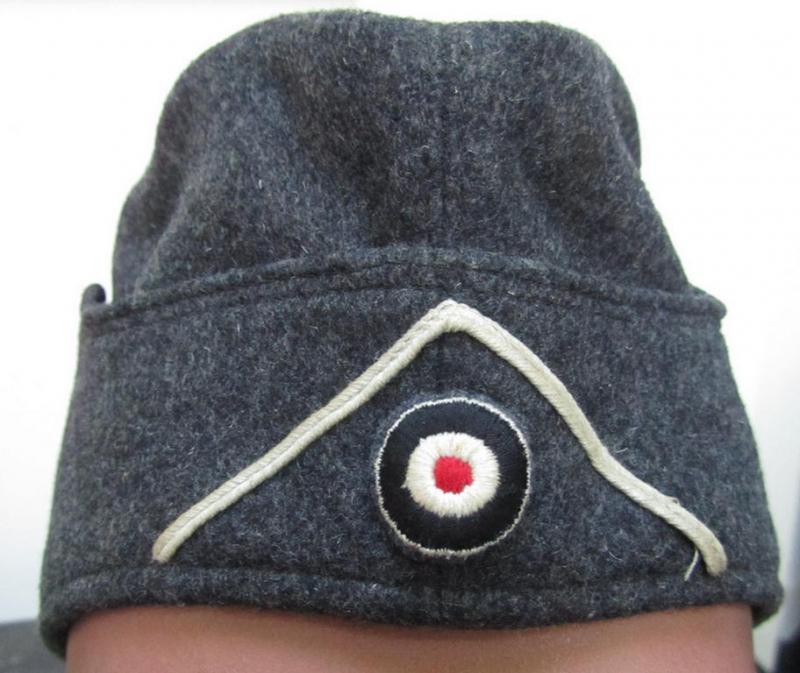 Attractive, typical darker-greyish-blue-coloured, so-called: German Red Cross (ie. 'Deutsches Rotes Kreuz' or: 'DRK' EM- (ie. NCO-) type side-cap (ie. 'Schiffchenmütze für Mannschaften u. Unteroffiziere des deutschen Rotes Kreuzes')