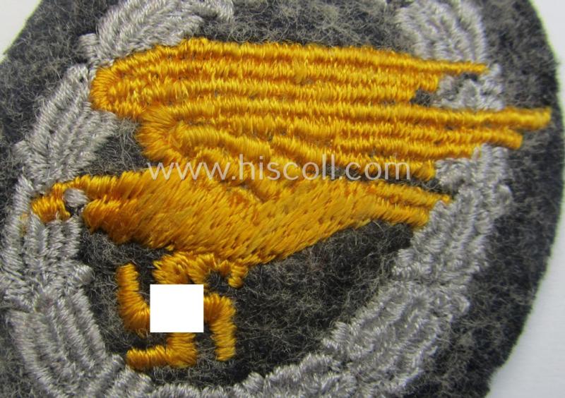 WH (Luftwaffe) 'Fallschirmschützen-Abzeichen in Stoff' (or: cloth-based paratroopers' jump-badge) that is nicely machine-embroidered and being of the so-called: 'padded version'