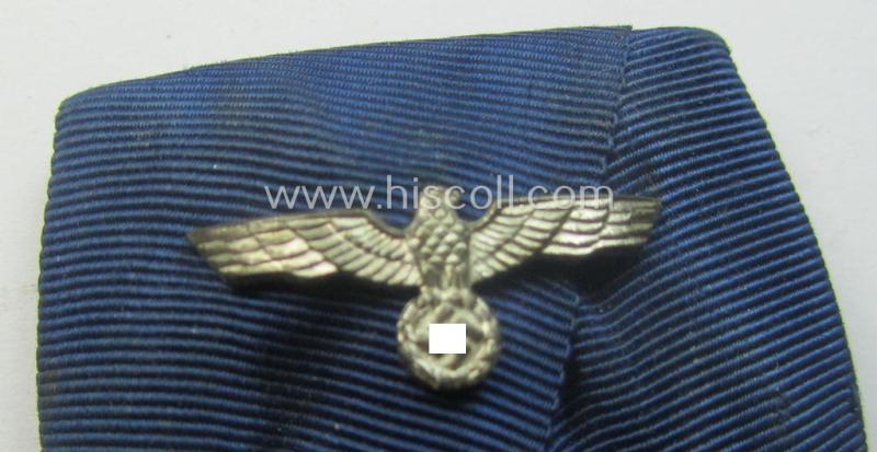 Bright-silver-toned WH (Heeres o. KM) so-called: 'Einzelspange' showing a: 'WH-Dienstauszeichnung 4. Stufe' (as was intended for 4 years of loyal-service) and that shows a detailed, Heeres o. KM-type-eagle-device, period-attached