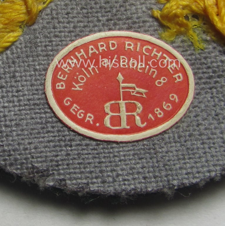 WH (Heeres) hand-embroidered, trade- ie. special-career arm-patch as was intended for a: 'Waffenmeister' (or: weapon-equipment NCO) being a maker-marked(!) example as executed on darker-green-coloured wool