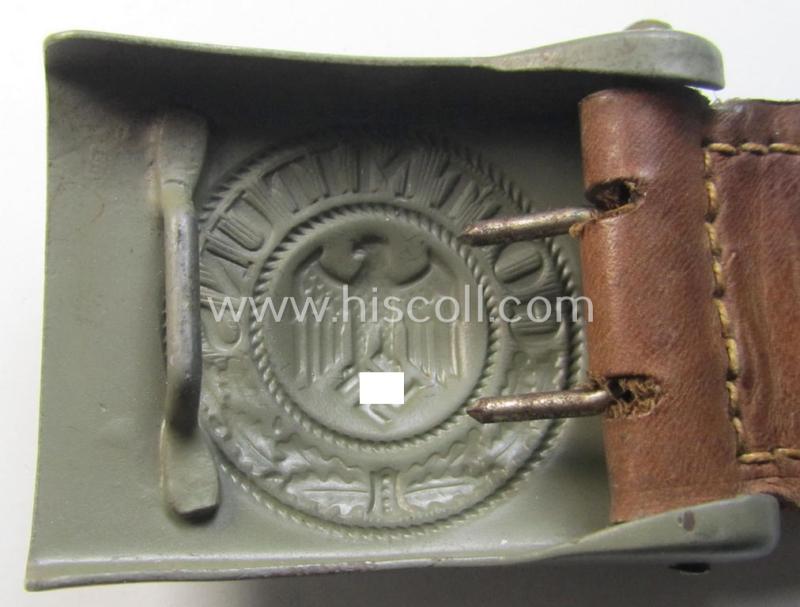 Superb, WH (Heeres) field-grey-coloured- and/or steel-based belt-buckle being (an unusally seen!) non-maker-marked- nor dated example that comes mounted onto its (light-brown-coloured) leather-based tab and that comes in a wonderful condition