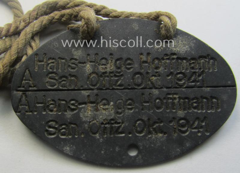 Interesting, early-war- (albeit 'standard-issue'-) pattern, WH (Kriegsmarine) typical zinc-based- and/or greyish-silver toned ID-disc (ie. 'Erkennungsmarke') bearing the engraved text that simply reads: 'Hans-Helge Hoffmann - San.Offz. Okt. 1941...