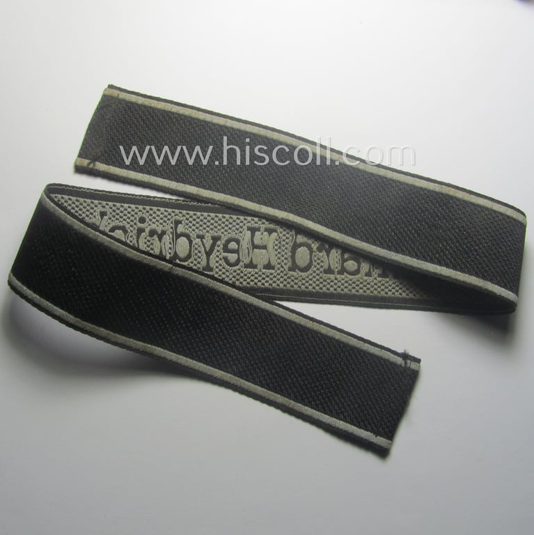 Waffen-SS, 1943-pattern cuff-title (ie. 'Ärmelstreifen') depicting the machine-woven Latin script text in silver-grey linnen as was intended for a member of the: 'SS-Geb.Jäg.-Rgts. 6. (u.11.)': "Reinhard Heydrich"