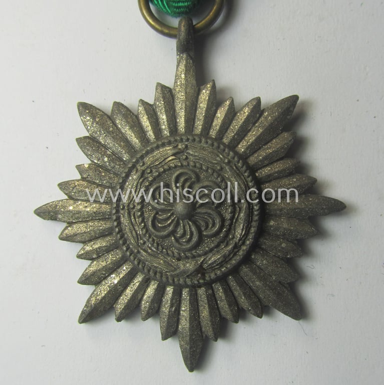 WH-related 'Verdienstauszeichnung für Angehörige der Ostvölker, 2. Kl. in Silber ohne Schwn.' (being a 'Feinzink'-based example that comes mounted onto its period ribbon ie. 'Bandabschnitt')
